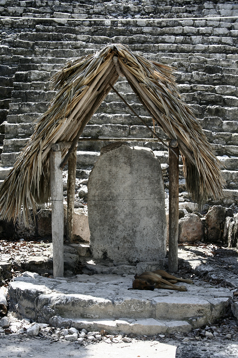 coba ruins, writing on a rock under a hut roof