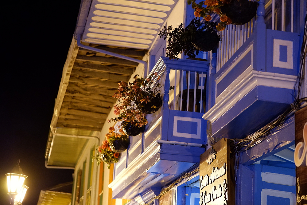 Pereira, Colombia: Mountains, cities, and delicious sweet drinks: close of of blue balconies lit up by the street lights 