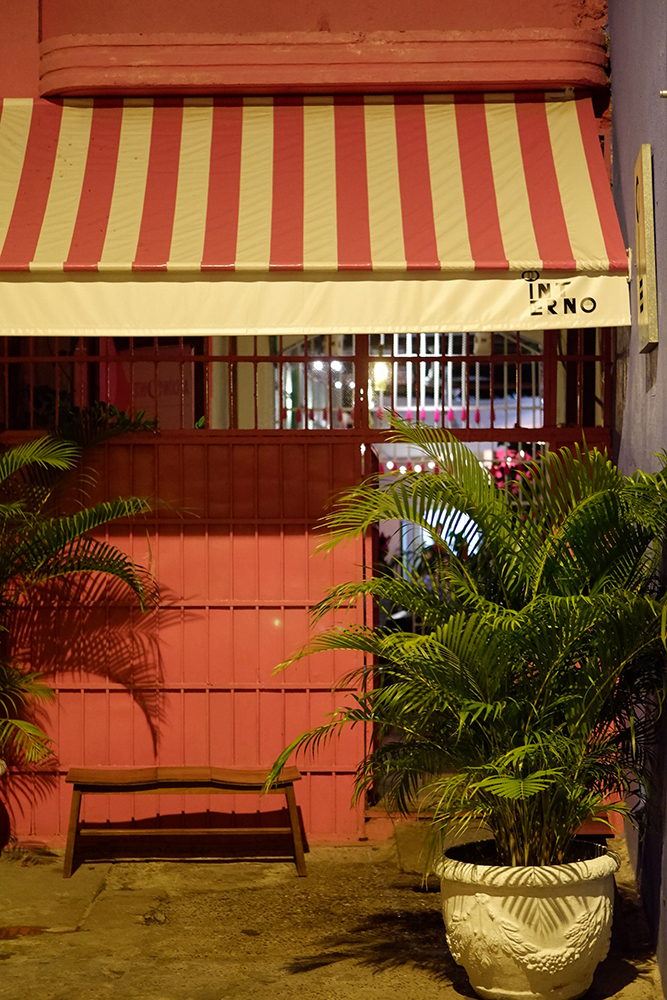 What to do and see Cartagena's Walled City and other Colombian basics: Inferno restaurant entrance with a pink striped awning and a large plant by the door