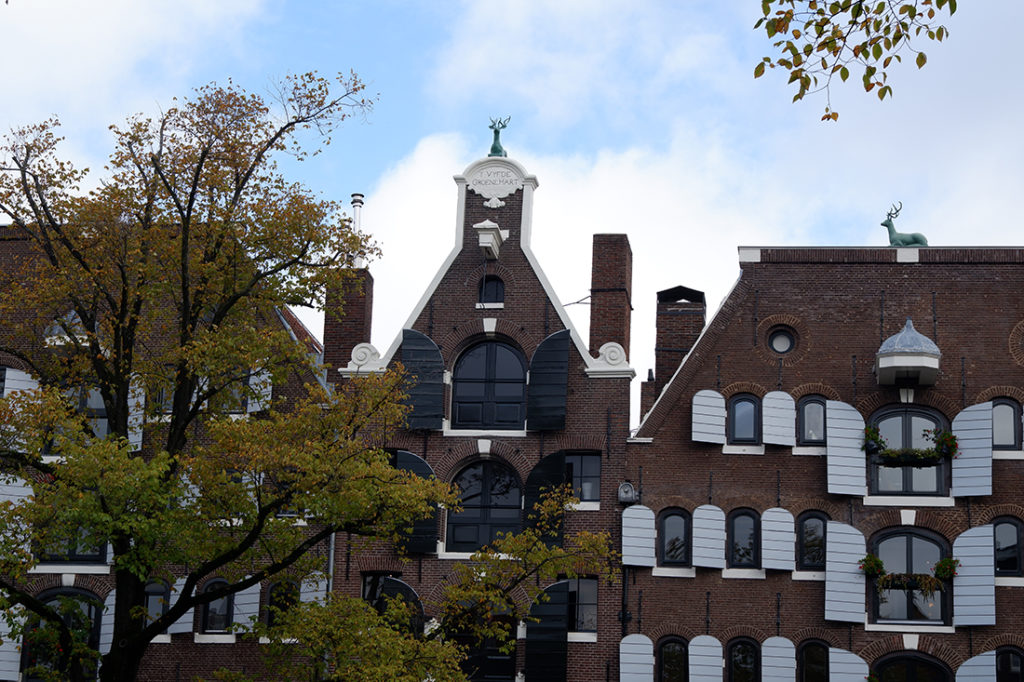 Exploring Jordaan, the historic neighbourhood in Amsterdam: top of the traditional brown buildings lined up