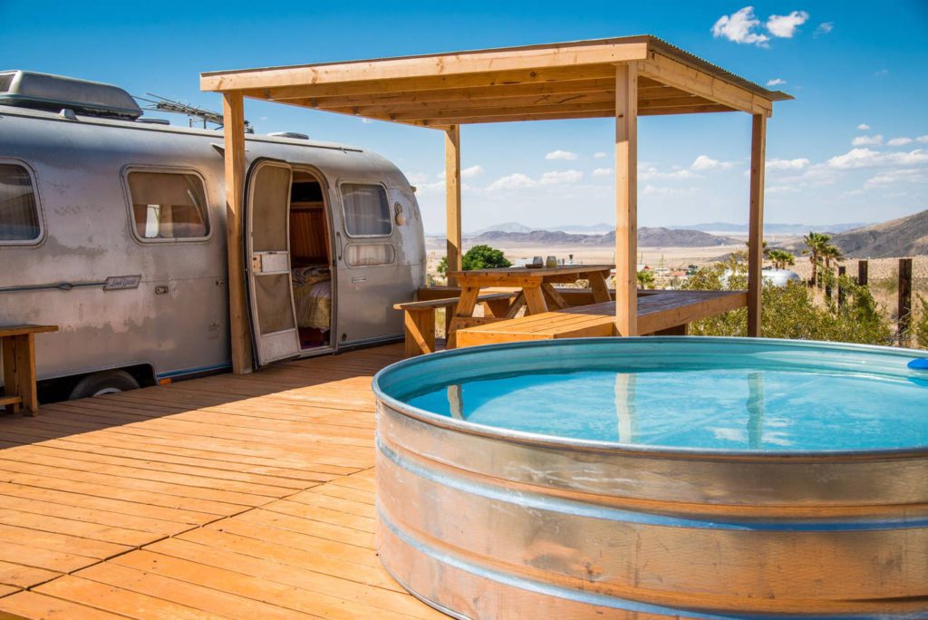 6 unique AirBNB homes in unique locations: camper van house with a hot tub outside on a wooden deck