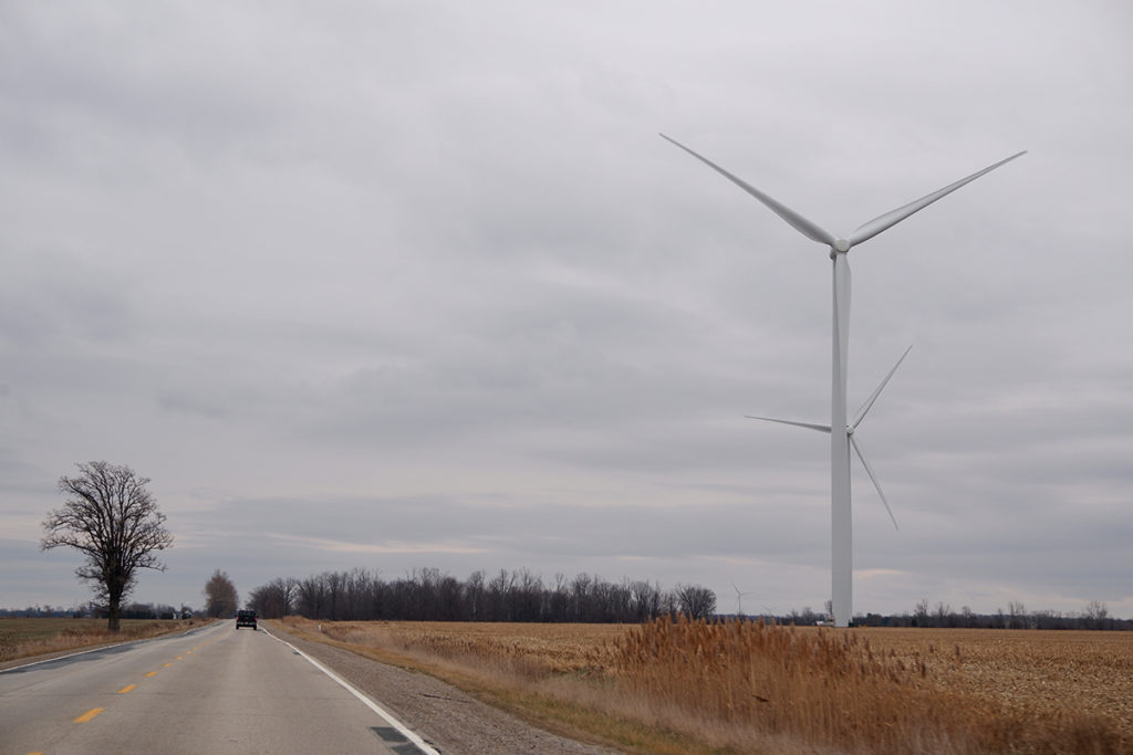 Finding ways to release the pandemic-related apathy in small strides: image of an open road with a farm on the side and a windmill 