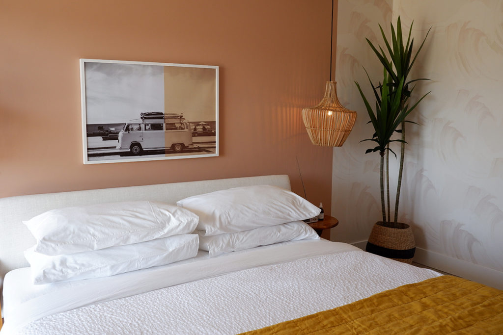 The June Motel: A chic stay in Sauble Beach: bedroom with a photo art print and a green palm 