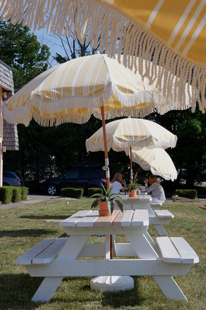 The June Motel: A chic stay in Sauble Beach: yard with picnic tables and umbrellas 