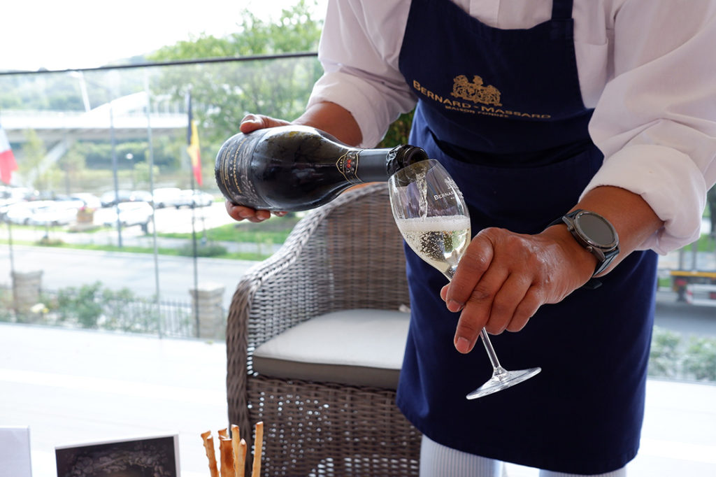 The views & flavours of the Luxembourg wine country: a man is pouring sparkling wine into a glass