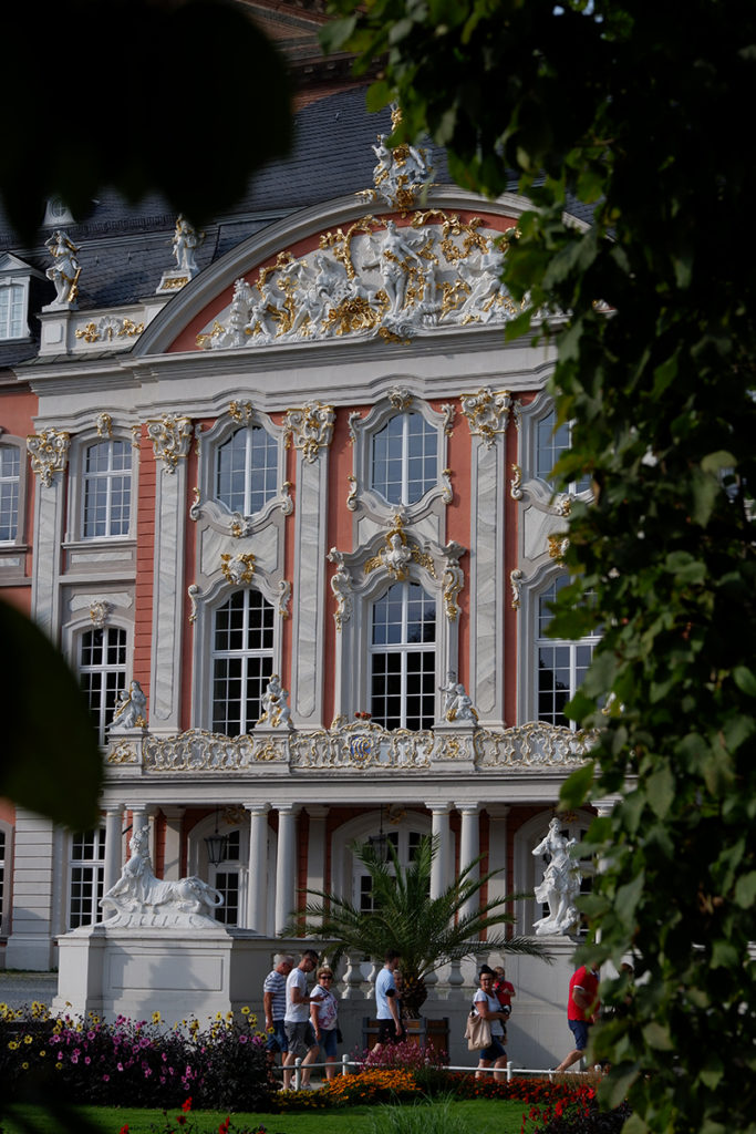 Trier in pictures Roman history, wine, and architecture: Kurfürstliches Palais close up of the front through greenery