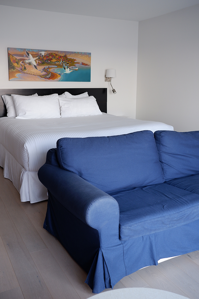 Riôtel Percé king bed and blue couch 