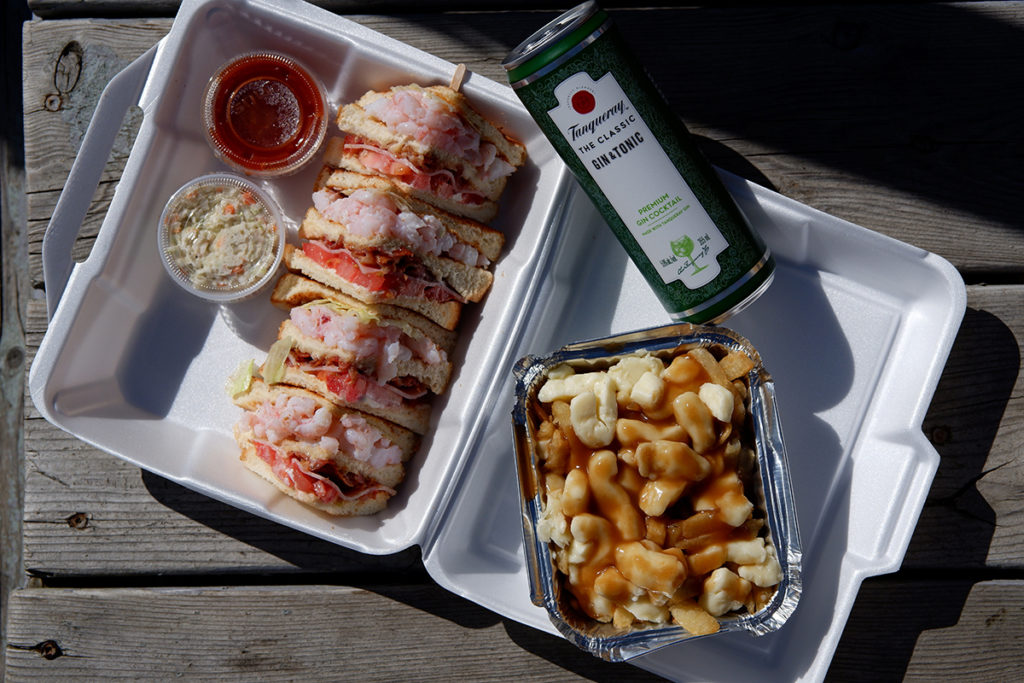 Quebec Maritimes infamous shrimp club sandwich with a poutine and a gin and tonic 