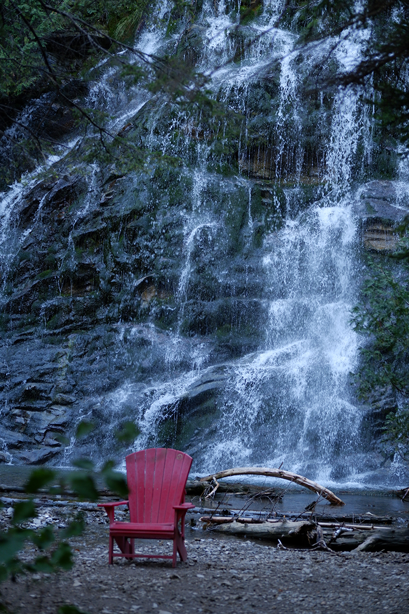 waterfall with a red chair in front of it