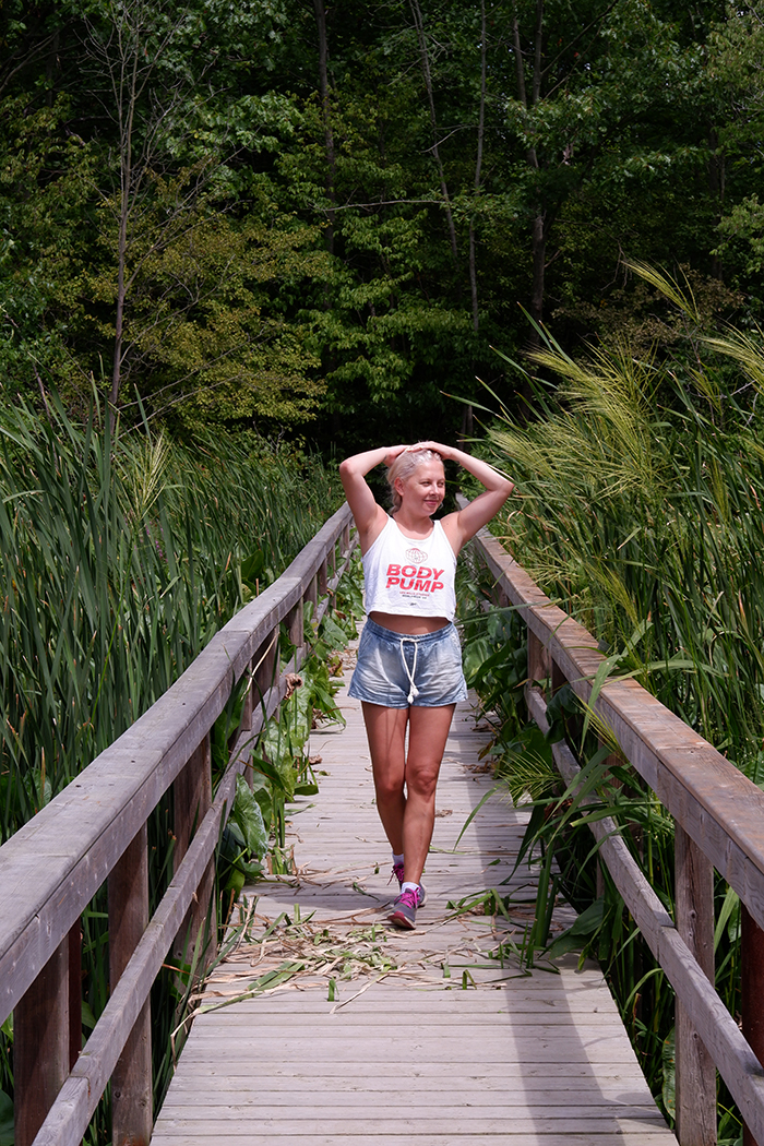 A woman standing on a boadwalk at the Selkirk Provincial Park, Wheeler's Walk Trail