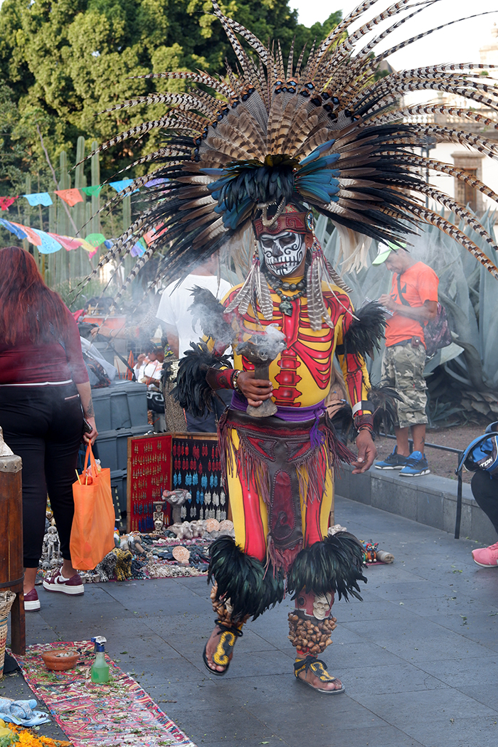 Traditional dancer performing in the Zócalo square. Dressed in feather crowns with painted faces and elaborate outfits. 