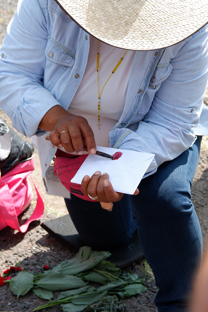 A woman drawing a red circle on a white envelope 