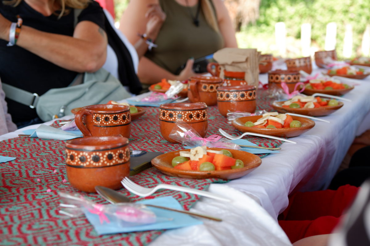 A table set for breakfast with fruit plates and coffee cups