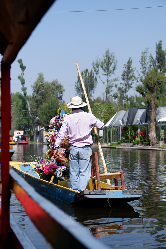 Male vendor selling flower crowns on a trajinera