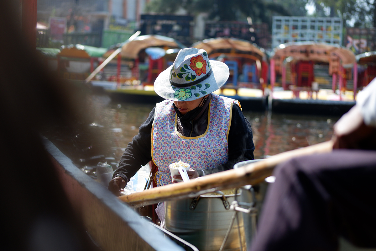 Female vendor making corn cups on a trajinera