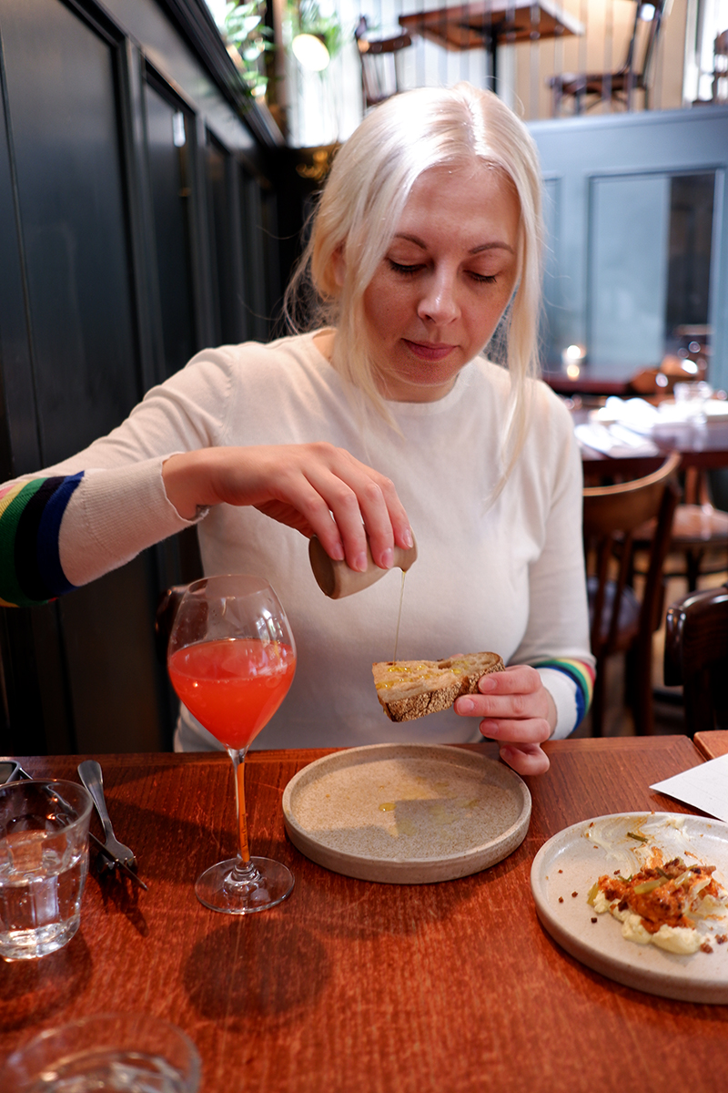 My favourite 8 bars and restaurants in Glasgow: Celentano's a woman pouring olive oil on sour dough bread