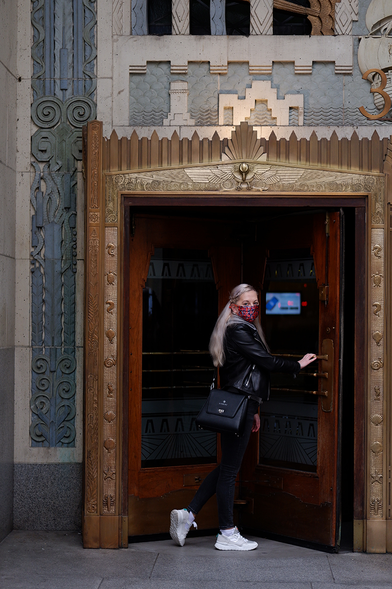 Revolving door into the Marine Building, a woman pushing it forward